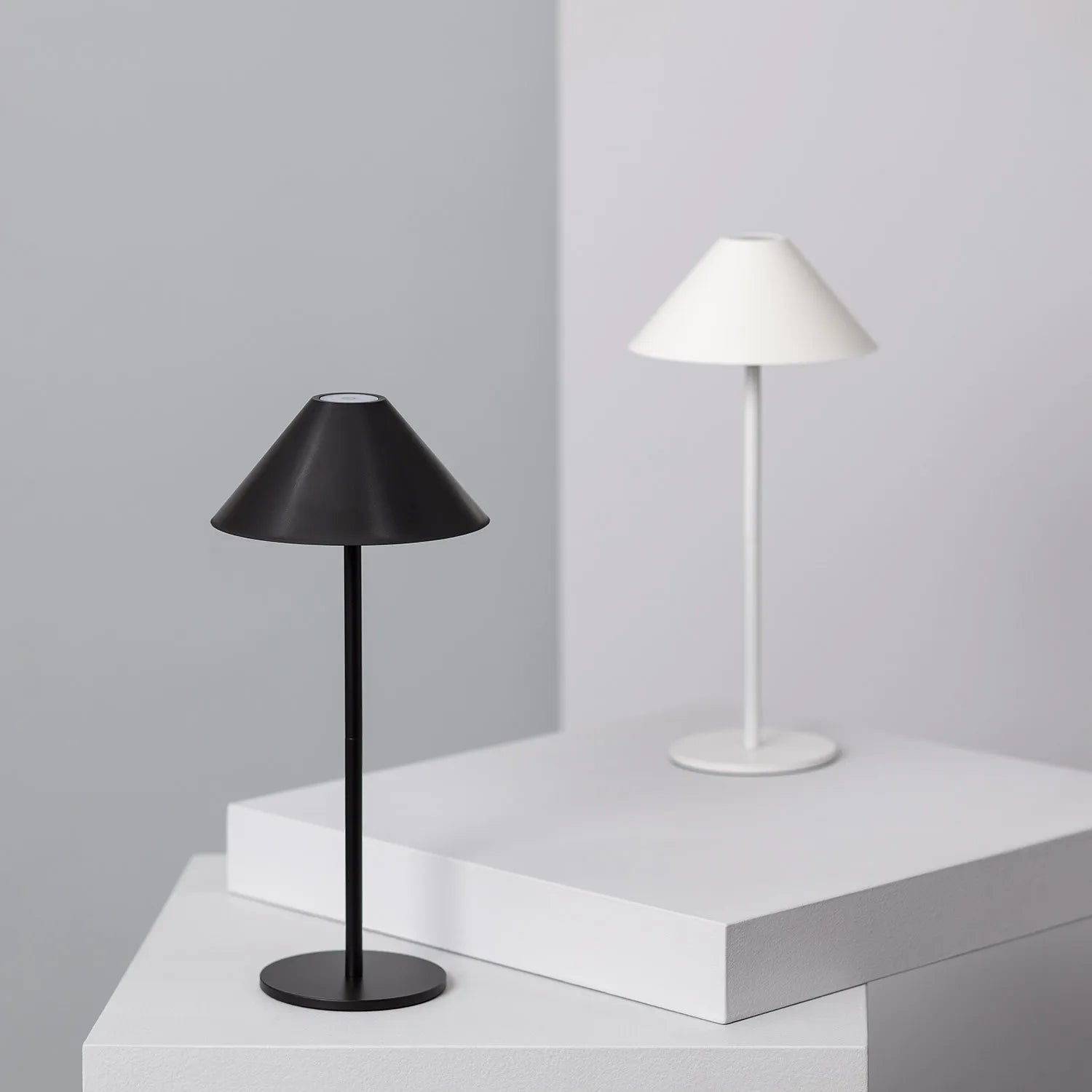 Przenośna lampka LED Claeted w kolorze białym na stole – minimalistyczny design
